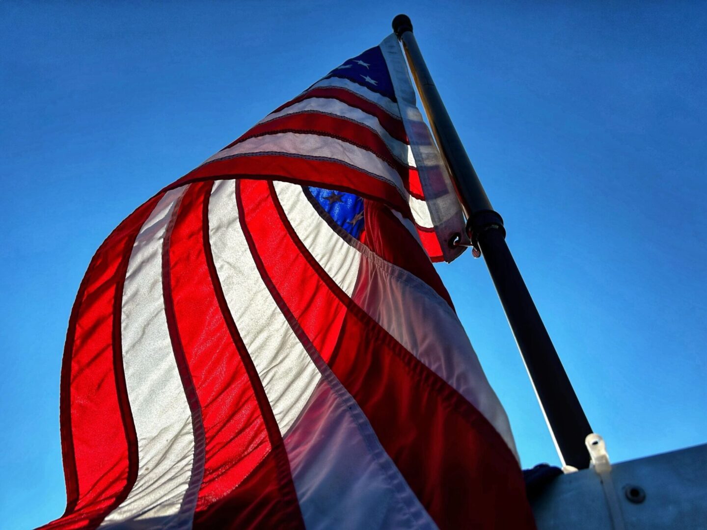 A close up of an american flag on the top of a pole