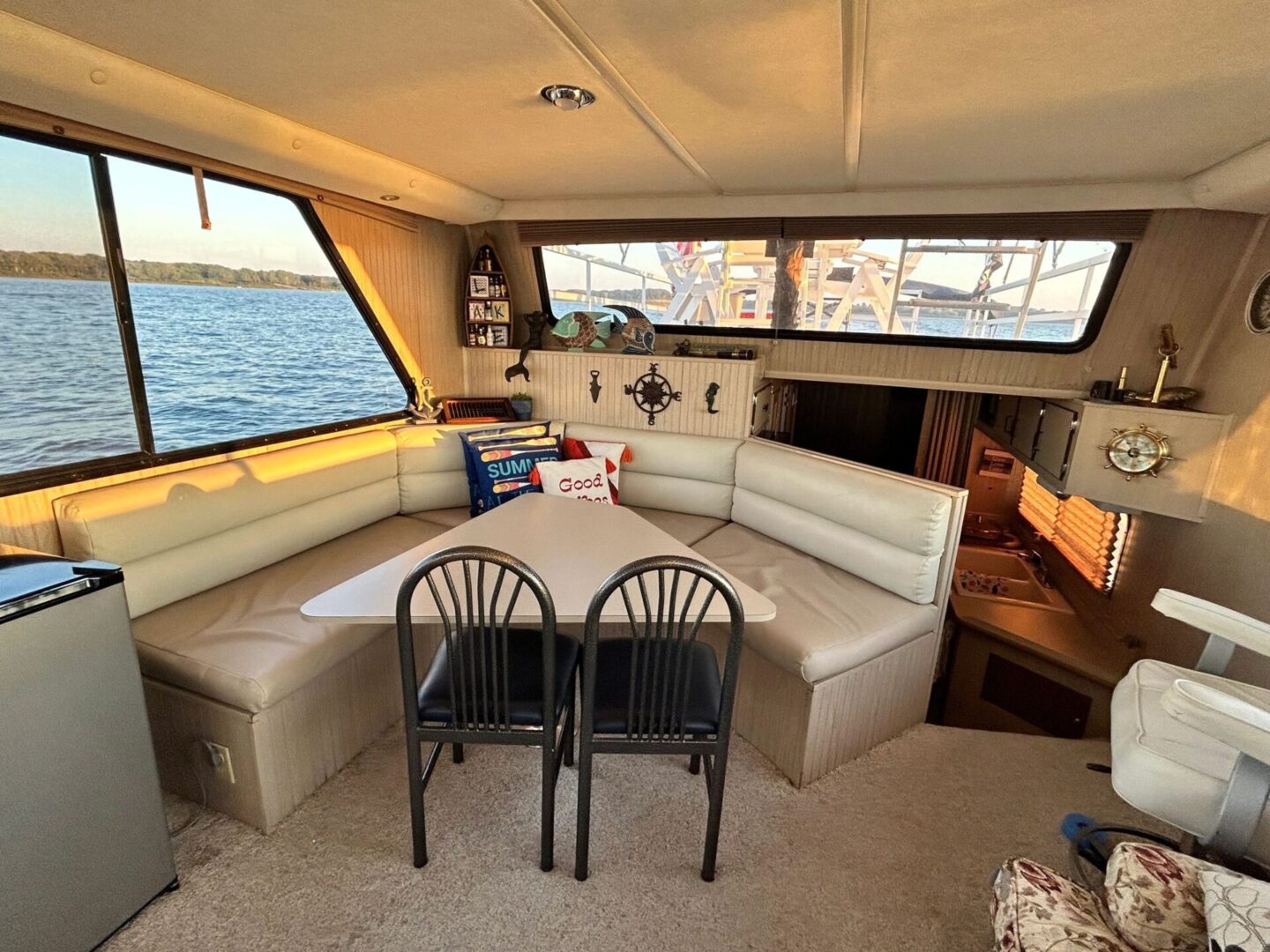 A boat with two chairs and a table in the middle of it.