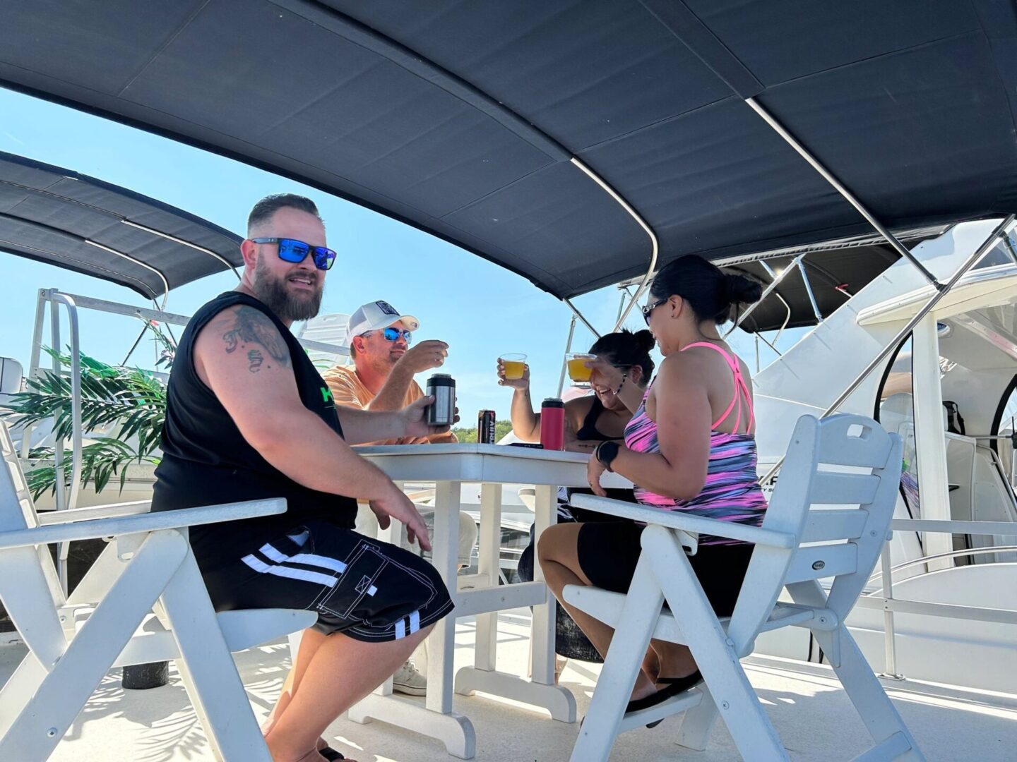 A group of people sitting at tables under an awning.