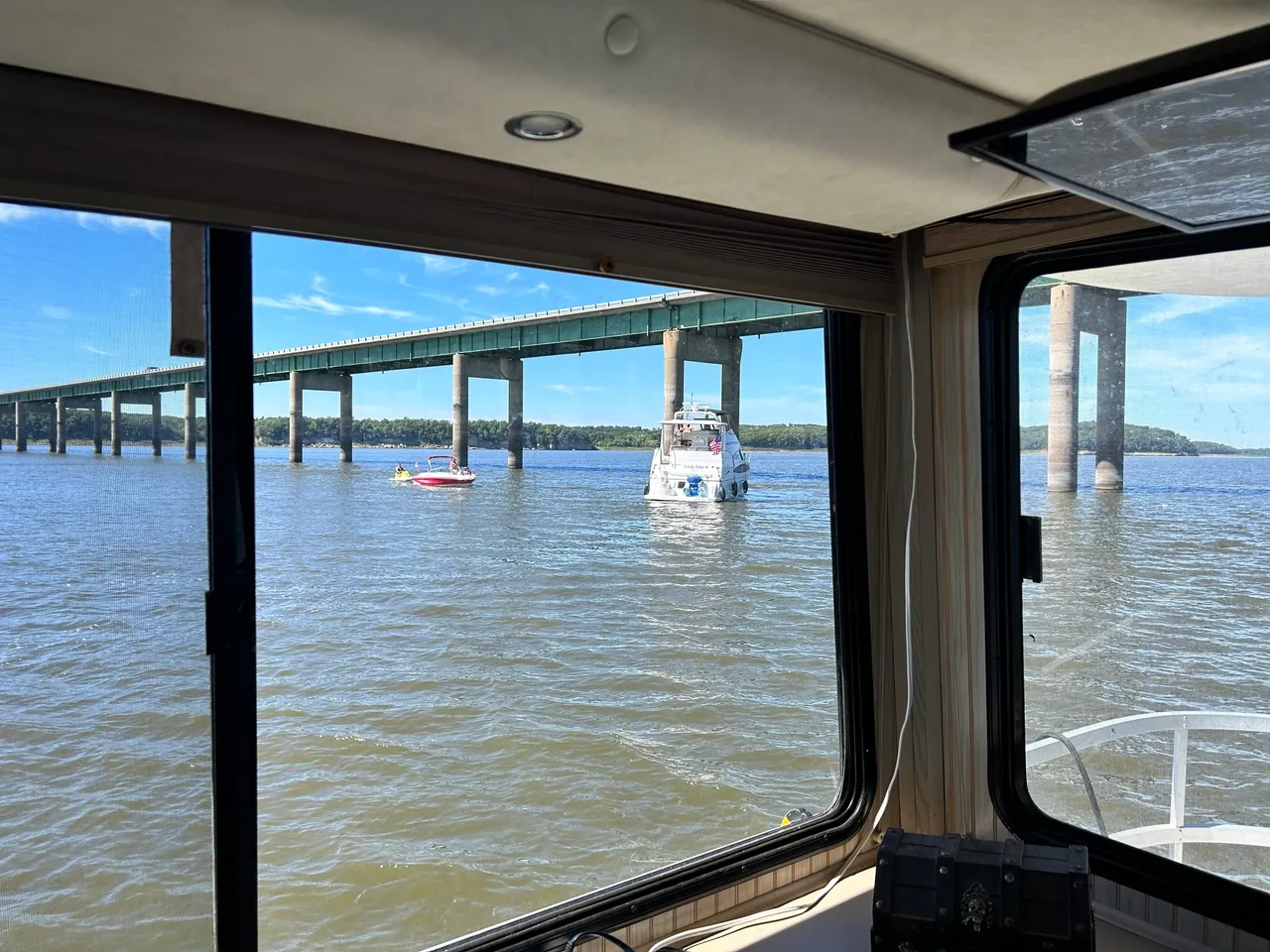 A boat is in the water near a bridge.