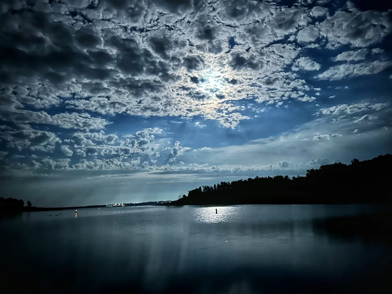 A body of water with clouds in the sky