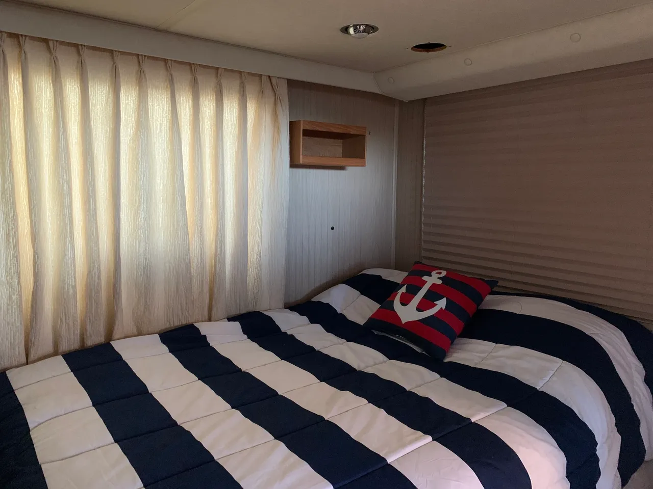 A bedroom with a bed, window and curtains.