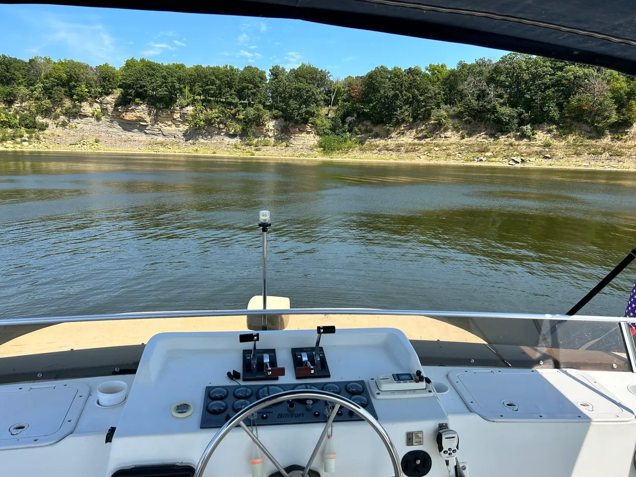 A boat is on the water with trees in the background.