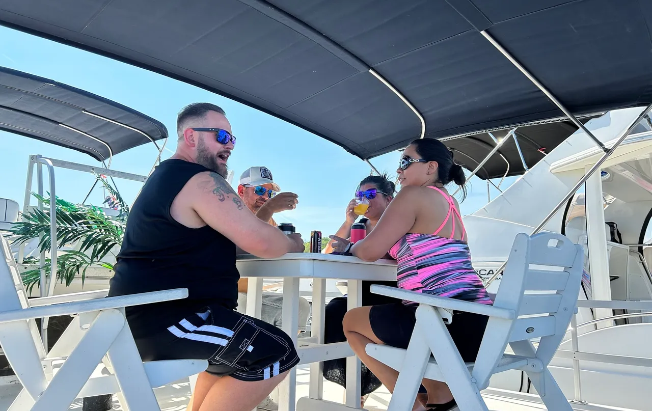 A group of people sitting at tables under umbrellas.