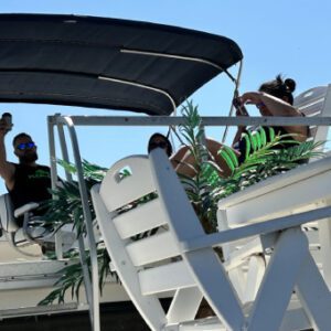 A boat with people sitting on it and some plants